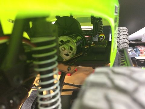 1989 Ford Bronco - The underside of a bright green RC car reveals its motor and suspension system.