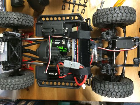 1989 Ford Bronco - This is a close-up overhead view of an RC car chassis, showing its mechanical components and tires.