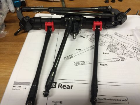 1989 Ford Bronco - Assembly instructions for an RC car's rear suspension system are laid out with the parts.