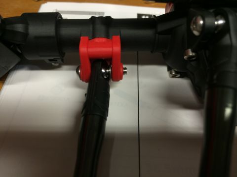1989 Ford Bronco - Close-up of a red bracket on a black suspension part, likely for an RC vehicle.