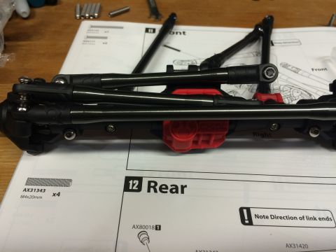 1989 Ford Bronco - Close-up of RC car suspension components laid out on assembly instructions.