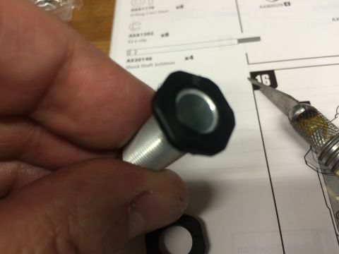1989 Ford Bronco - Close-up of an RC car shock absorber part with assembly instructions in the background.