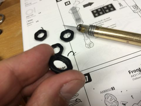1989 Ford Bronco - Close-up of a manual with parts and a hobby knife, showing assembly instructions.