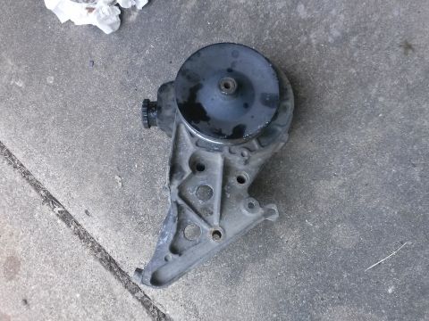 1996 Ford Bronco - Power steering pump assembly with pulley shown on concrete surface.
