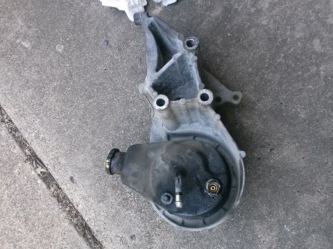 1996 Ford Bronco - A used power steering pump is shown resting on a concrete surface.
