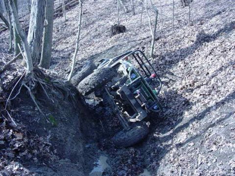 1992 Ford Bronco - An all-terrain vehicle is stuck in a ditch on a steep, wooded slope.