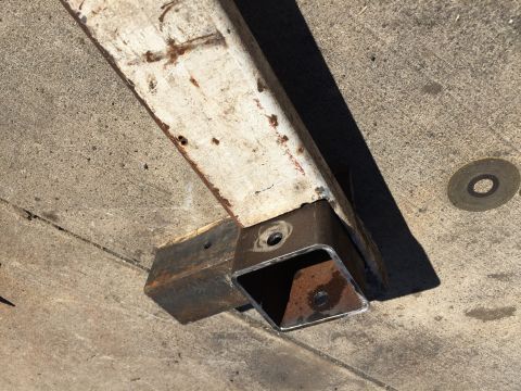 1996 Ford F-150 - A close-up view of a trailer hitch receiver assembly, showing welded metal components and rust.