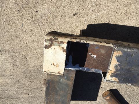 1996 Ford F-150 - A close-up view of a heavily rusted metal frame component, showing signs of wear and repair.
