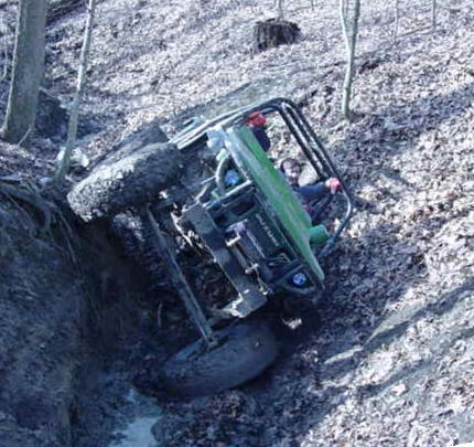 1992 Ford Bronco - An off-road vehicle is stuck at an angle in a muddy ravine.
