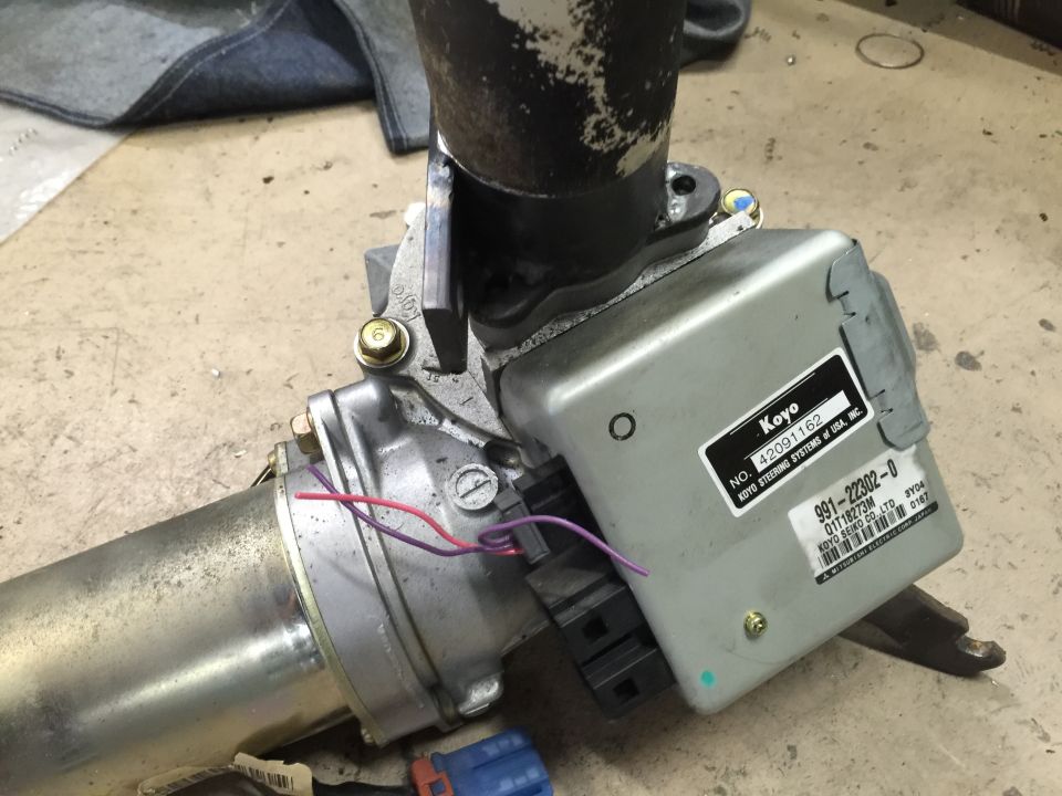 Close-up of a Koyo power steering motor and control unit with part numbers visible