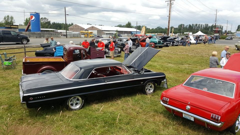 Black 1964 Chevrolet Impala with hood open, parked on grass