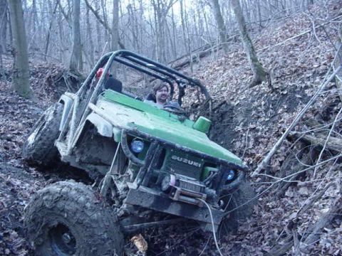 1992 Ford Bronco - Suzuki Samurai navigates a steep, wooded, muddy trail.