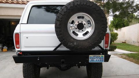 1979 Ford Bronco - The rear of a white 1979 Ford Bronco is shown, a large spare tire and a custom bumper with a Nevada license plate.