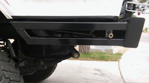 1979 Ford Bronco - Close-up view of the rear bumper and suspension of a vehicle.
