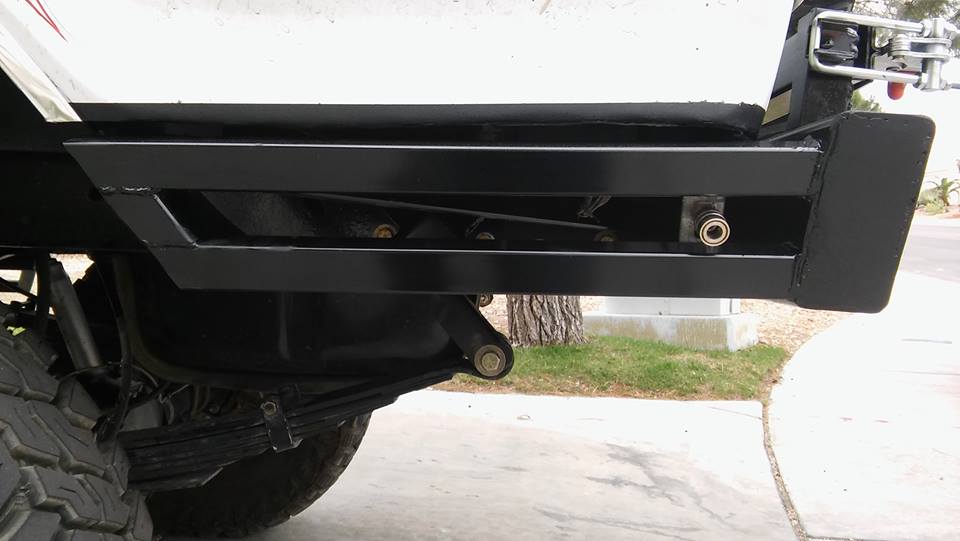 Black aftermarket rear bumper with visible suspension components and tire