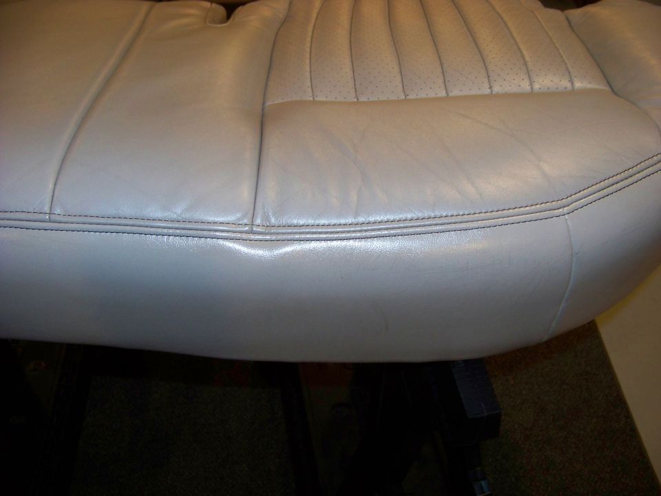 Light gray leather car seat with perforated backrest and double stitching