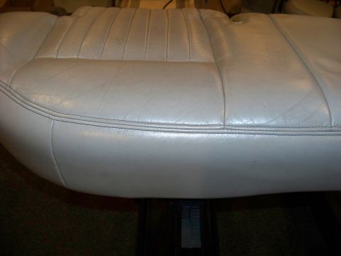2001 Mercury Grand Marquis - Close-up of a light gray leather car seat, showing its stitching and perforated sections.