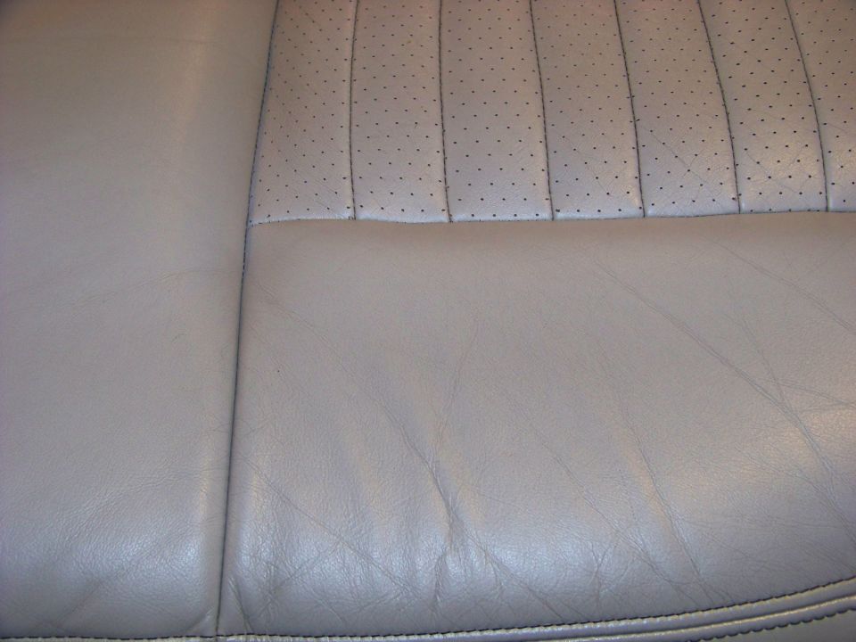 close-up of light-colored perforated and smooth leather car seat upholstery