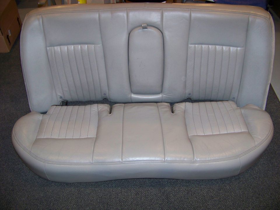 Gray leather rear car seat with pleated sections on the backrest and bottom cushion
