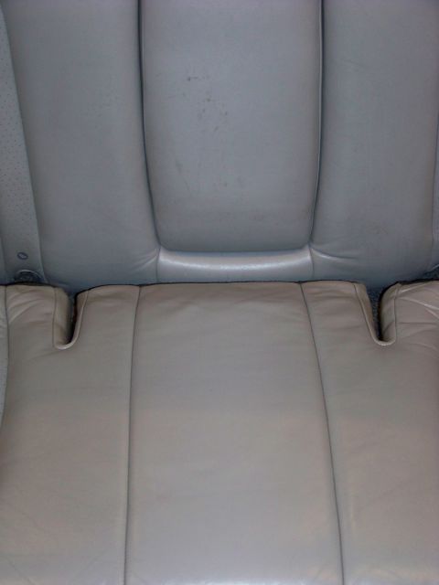 2001 Mercury Grand Marquis - The rear seat interior of a vehicle, showing light tan leather upholstery.