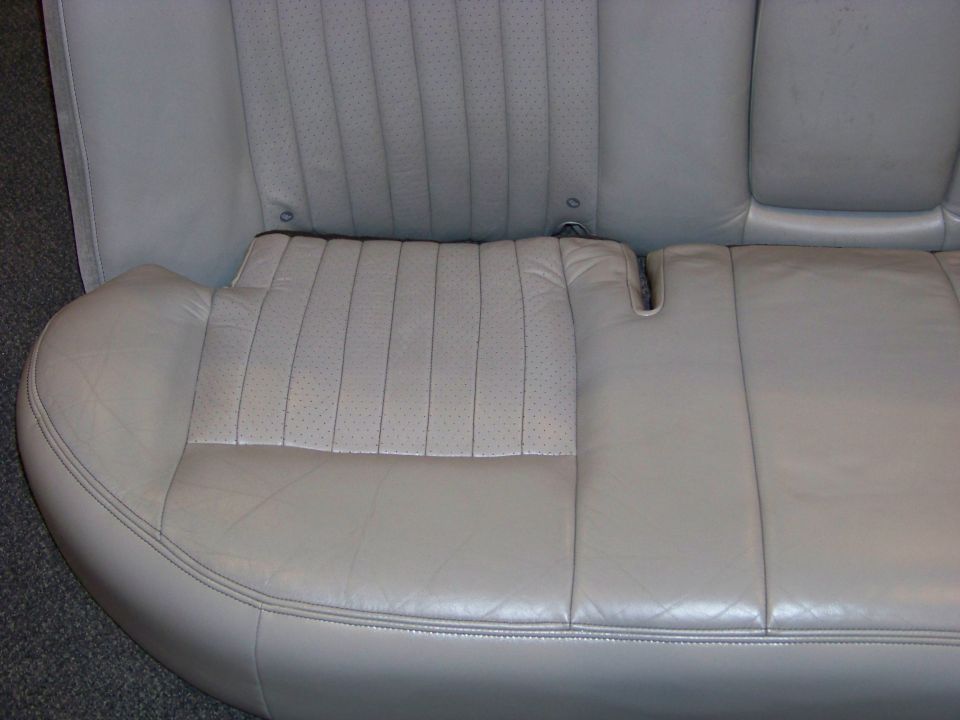 Light gray leather rear car seat with perforated inserts and stitching