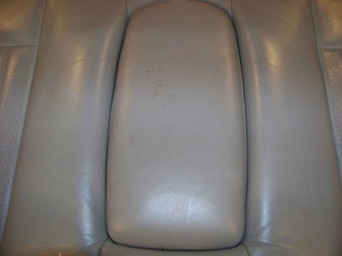 2001 Mercury Grand Marquis - Close-up of a tan leather rear seat armrest, showing some wear and tear.