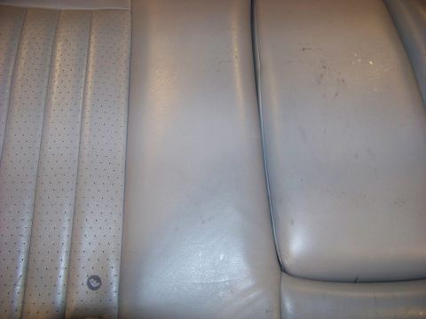 2001 Mercury Grand Marquis - The interior of a vehicle shows worn leather seats with a perforated section and a smooth section, along with a watermark.