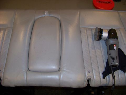 2001 Mercury Grand Marquis - A light gray leather car seat is shown with a polishing tool, suggesting interior maintenance.