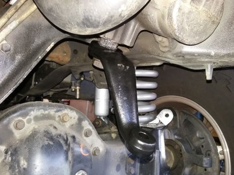 1996 Ford Bronco - Underside view of a vehicle's suspension system, focusing on a steering linkage component and coil spring.