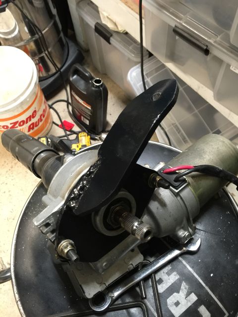 1965 Ford Mustang - Close-up of a power steering motor and linkage assembly, a black lever arm and exposed gears.