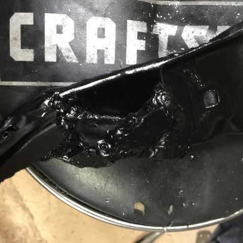1965 Ford Mustang - A close-up view of a black painted metal component, showing rough welds and the partial word 'CRAFTS'.
