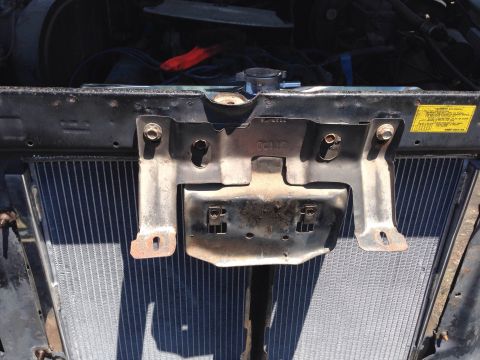 1979 Ford Bronco - Close-up view of a vehicle's radiator and its supporting metal bracketry.