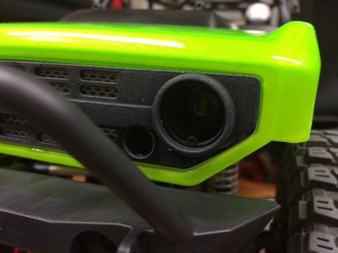 1989 Ford Bronco - Close-up of a bright green RC car body showing a detailed grille and headlight area.