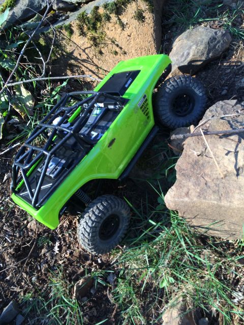 1989 Ford Bronco - A bright green RC rock crawler navigates a challenging, rocky outdoor course.