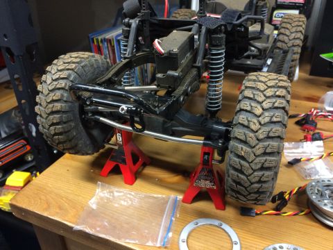 1989 Ford Bronco - RC car chassis and suspension components are visible, resting on jack stands.