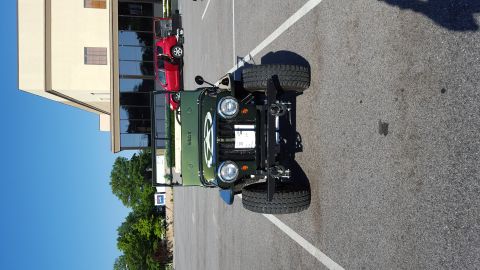 1948 Jeep Wrangler - A classic 1948 Jeep Wrangler is parked in a lot, showing its distinctive front grille and star emblem.