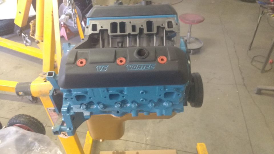 V6 Vortec engine on an engine hoist. Blue block, black valve covers