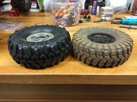 1989 Ford Bronco - Comparison of a clean and a used off-road tire for an RC car, displayed on a workbench.