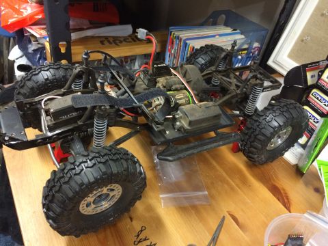 1989 Ford Bronco - The chassis of a remote control car is visible, with its tires and internal components clearly displayed.