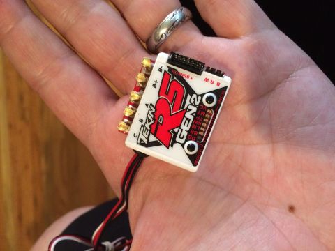 1989 Ford Bronco - A Tekin RS Gen2 electronic speed controller is held in a person's palm, showing its branding and wiring.