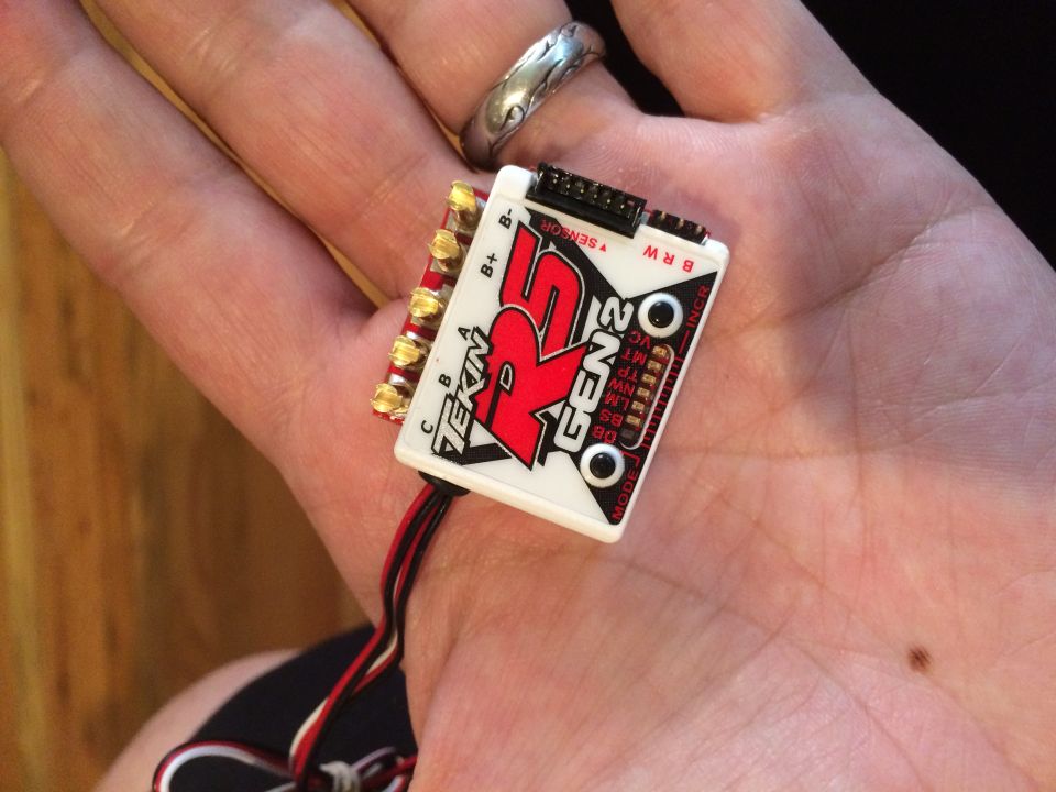 Tekin RS Gen2 electronic speed controller with red and black wires held in a palm