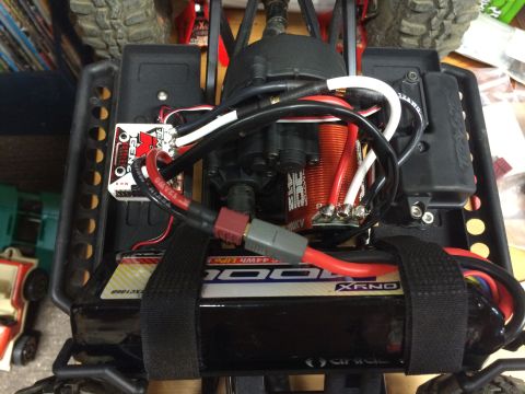 1989 Ford Bronco - Close-up view of the internal components of a radio-controlled car, including the battery and motor.