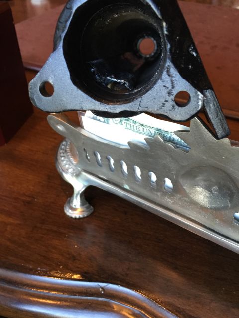 1965 Ford Mustang - A metal component is placed on a decorative silver tray holding US currency.