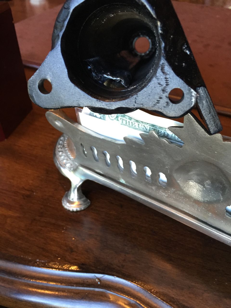 metal part resting on a silver tray with money inside