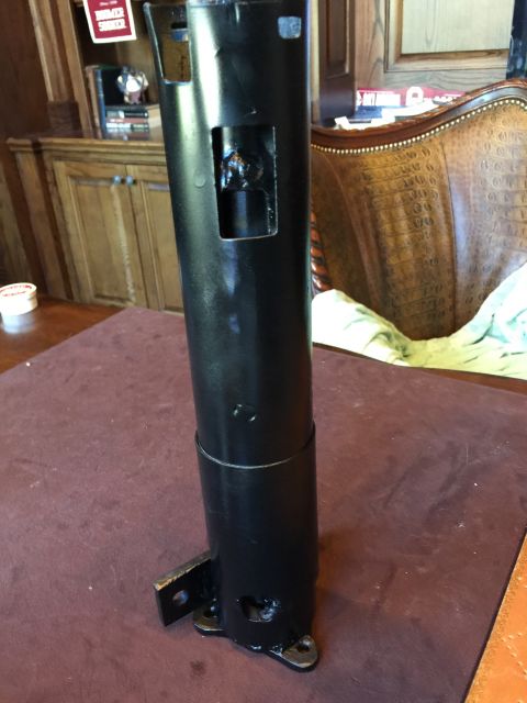1965 Ford Mustang - A black metal automotive part is shown in detail, with mounting brackets visible at the base.