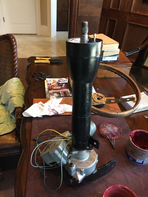 1965 Ford Mustang - A disassembled steering column and wheel are laid out on a table, surrounded by tools and a can of grease.