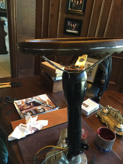 1965 Ford Mustang - A disassembled steering column and wooden steering wheel are shown on a table, surrounded by tools and a magazine.