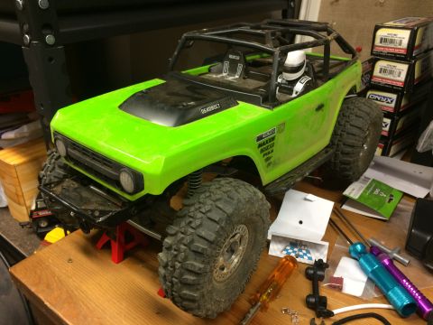 1989 Ford Bronco - This RC rock crawler, resembling a classic SUV, is displayed on a workbench with various tools and parts nearby.