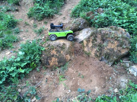 1989 Ford Bronco - RC rock crawler navigating a challenging, rocky outdoor course.