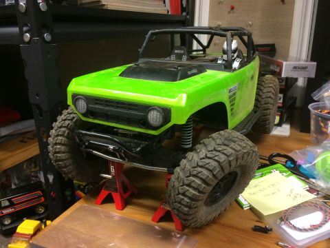 1989 Ford Bronco - RC rock crawler model with large tires, displayed on red jack stands.